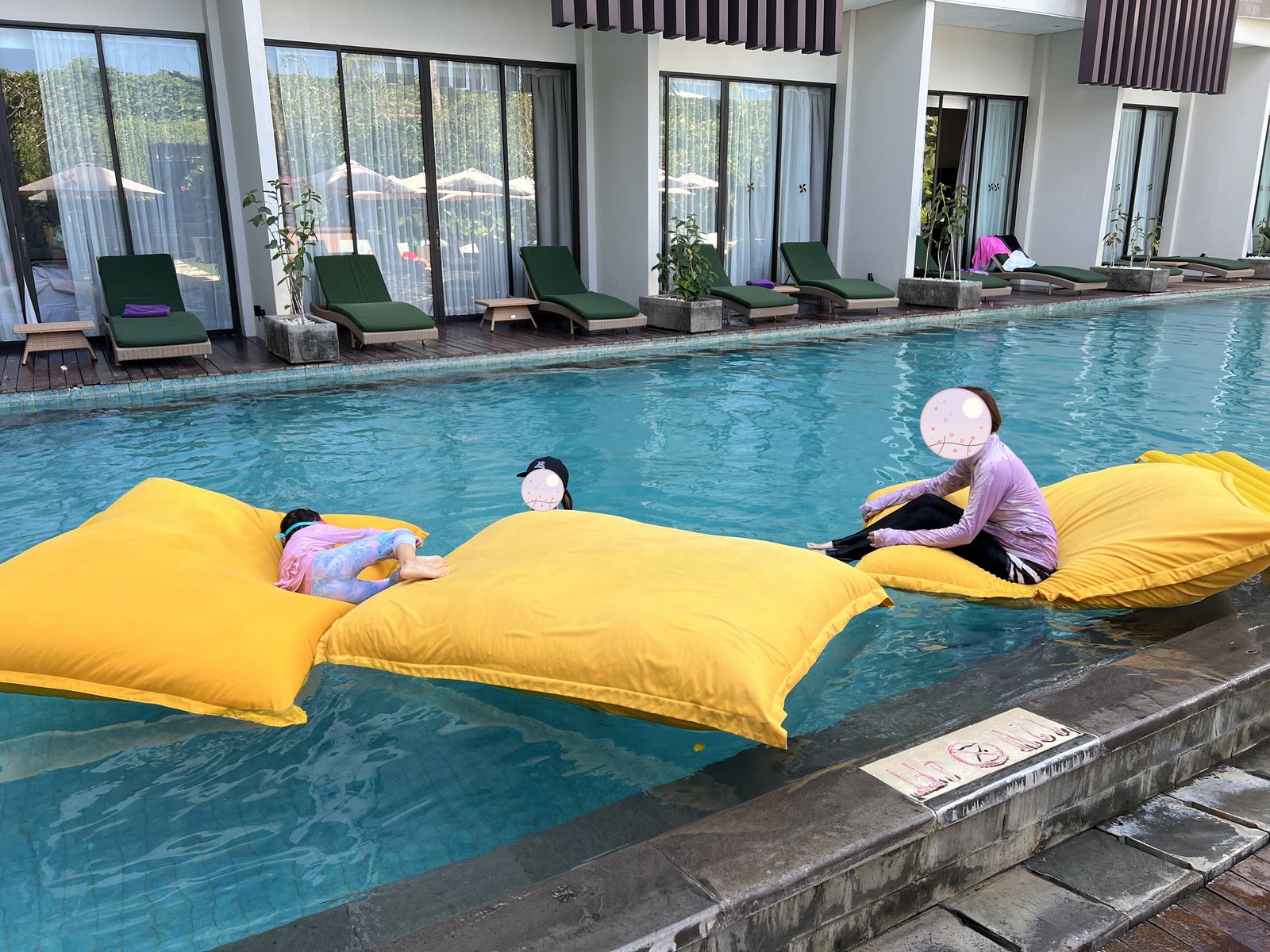Relaxing on a yellow bean-bag float in the pool 