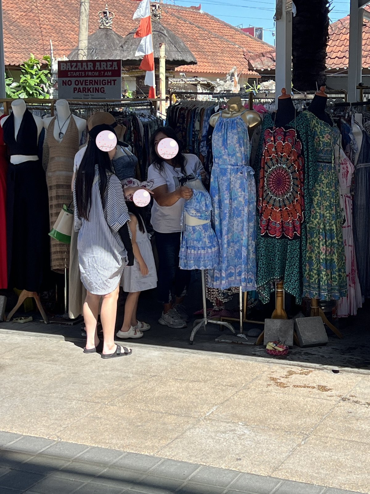 Picking out a dress at a bazaar stall 