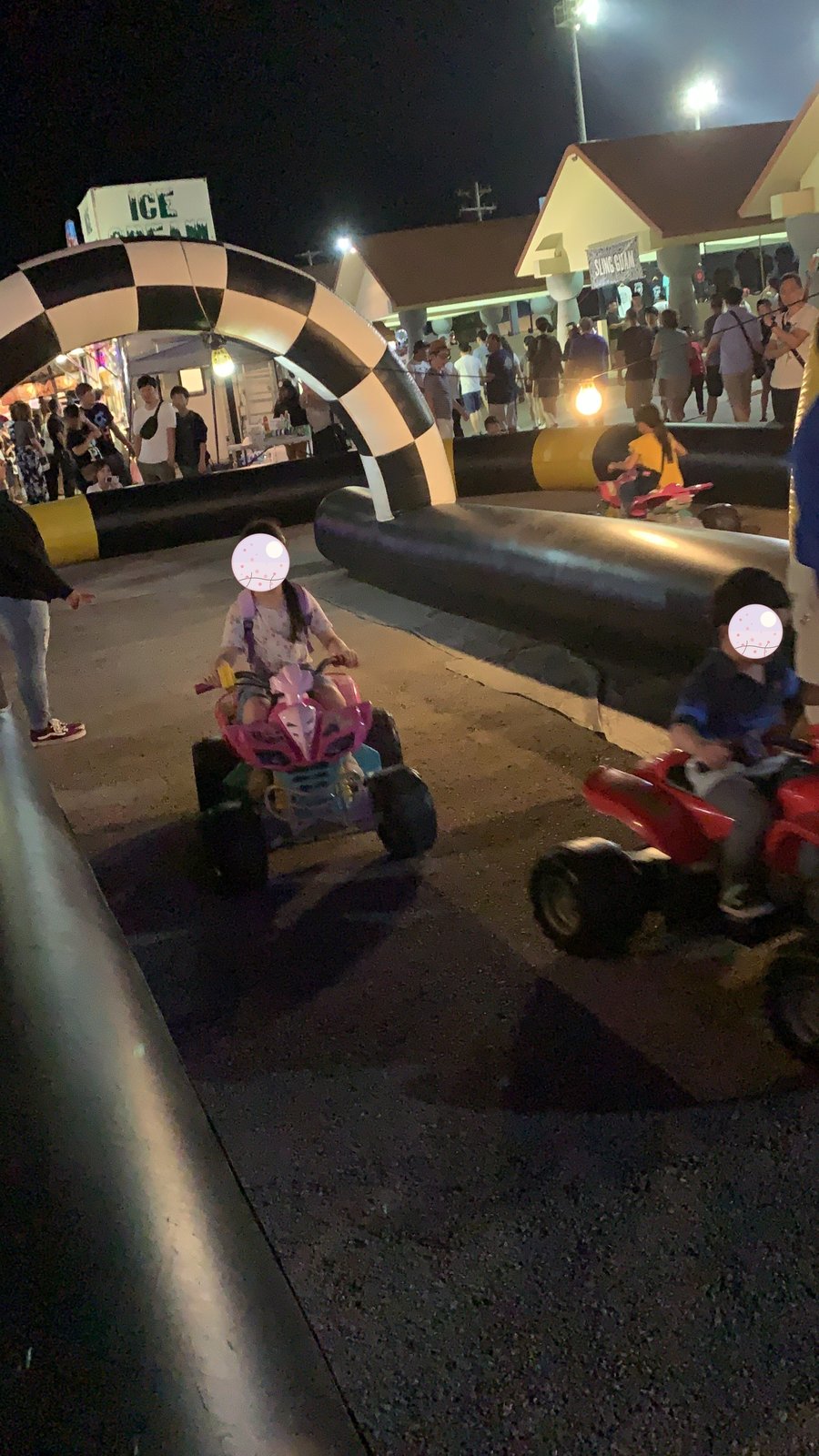 夜市の会場で電動カートに乗る子どもたち