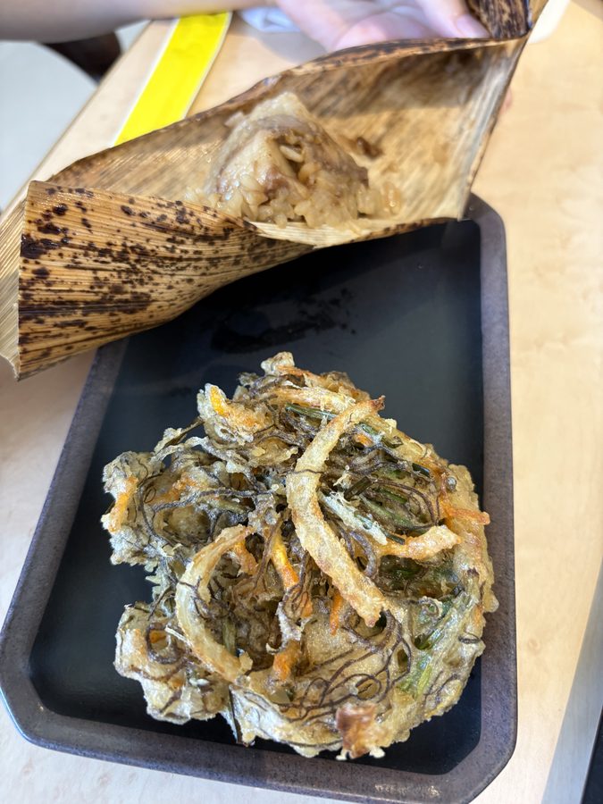 竹の皮に包まれたポーク玉子おにぎりと、もずくの天ぷら