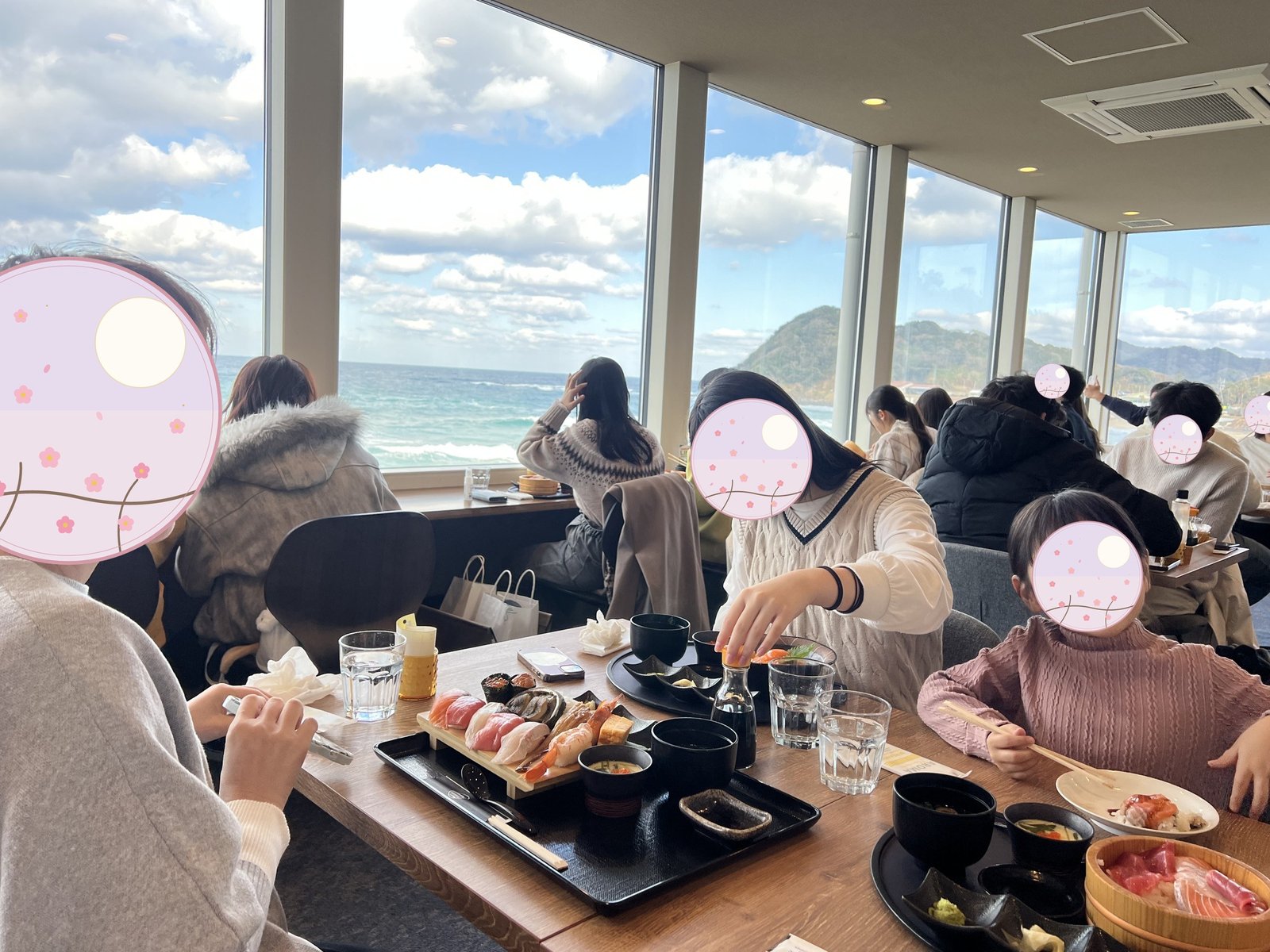 海を眺めながら食事をする家族