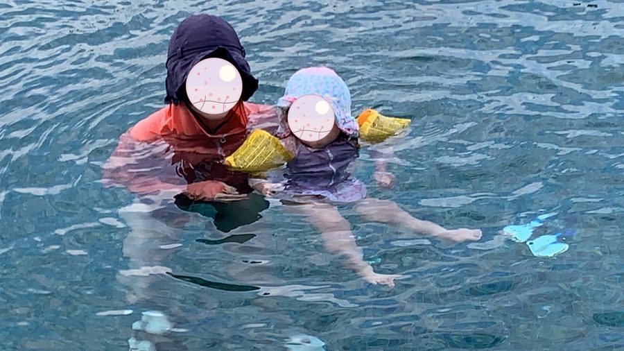 With arm bands on, getting used to the water little by little.