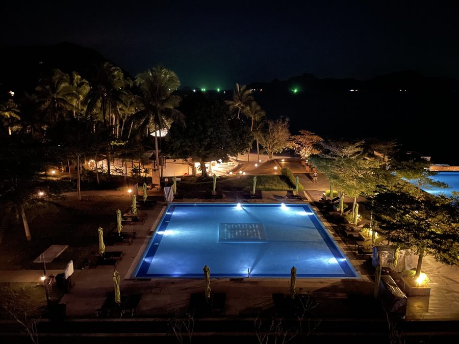 The villa's pool, lit up at night.