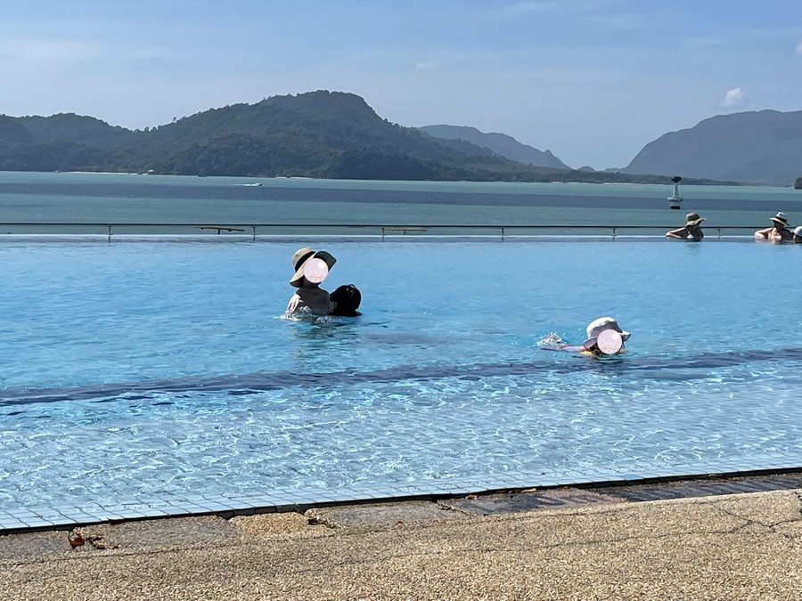 The two sisters swimming, faces just above the water.