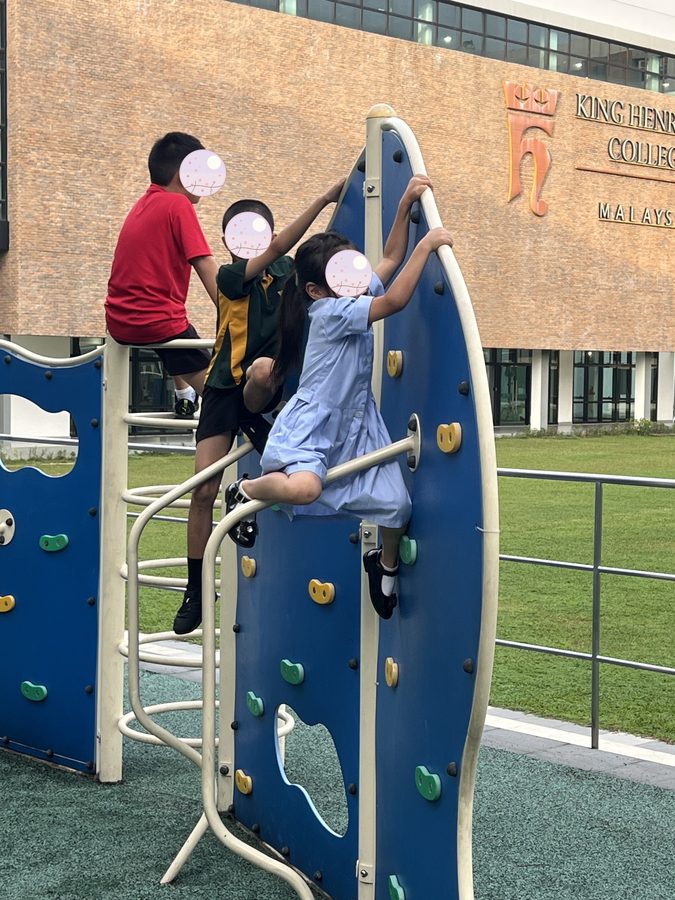 校庭の遊具。校舎に学校名が入っています