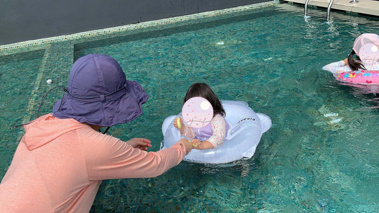 Reaching out to my child floating in the pool with water wings 