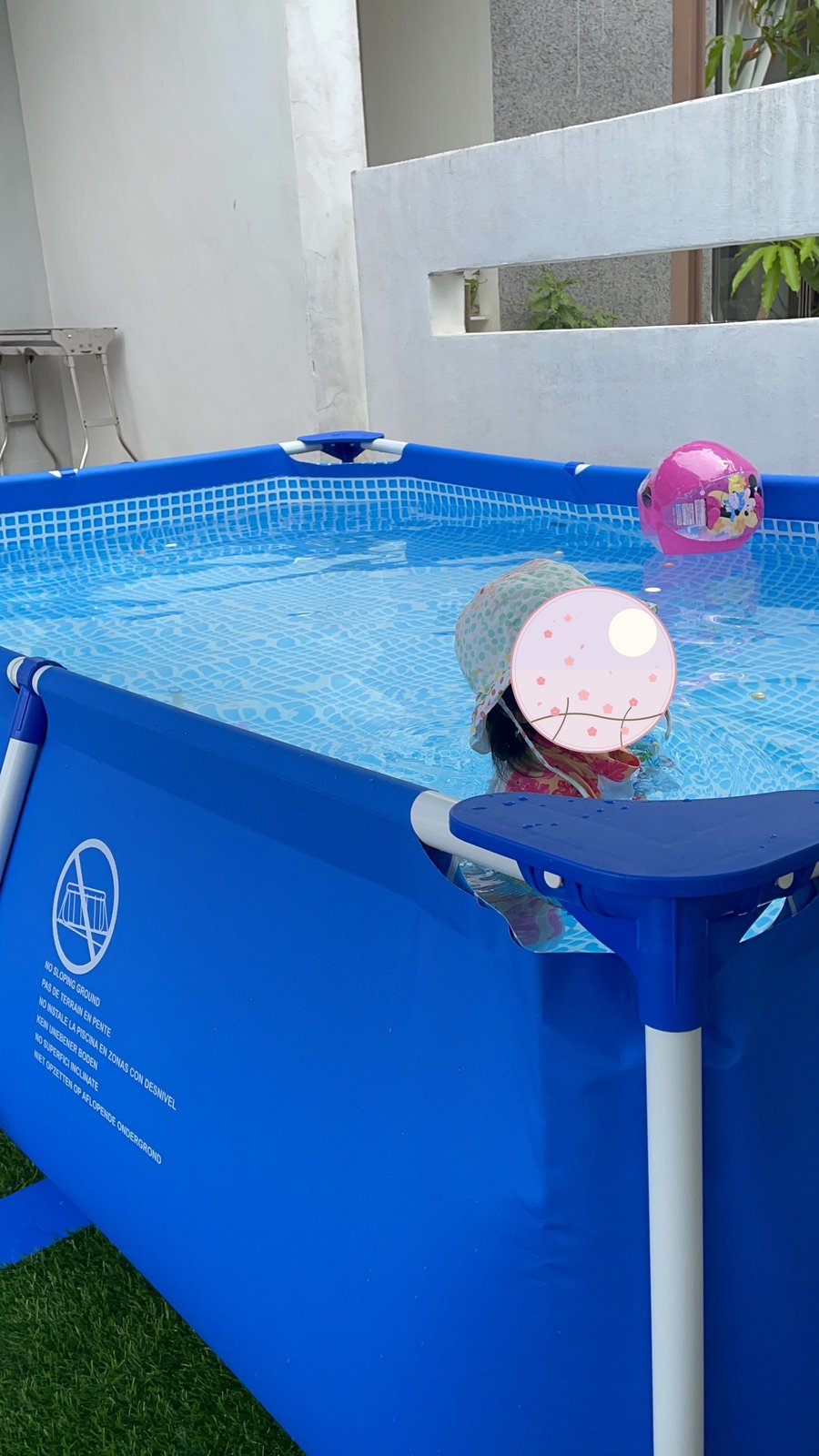 Playing in the blue framed pool in our backyard 