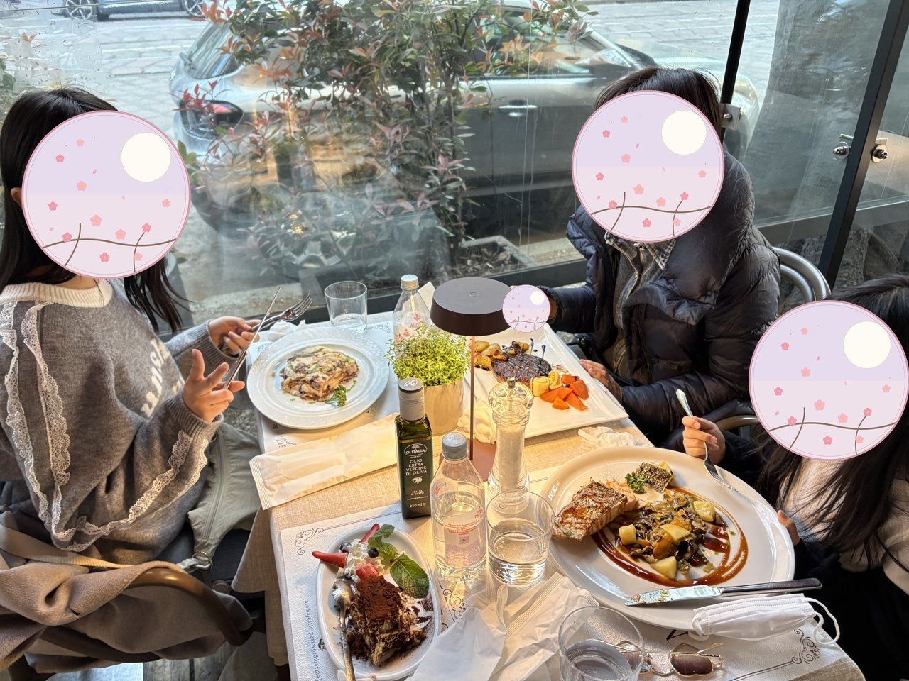 A relaxed dinner at a window-side table — pasta, a fish course and dessert, enjoyed as a family 