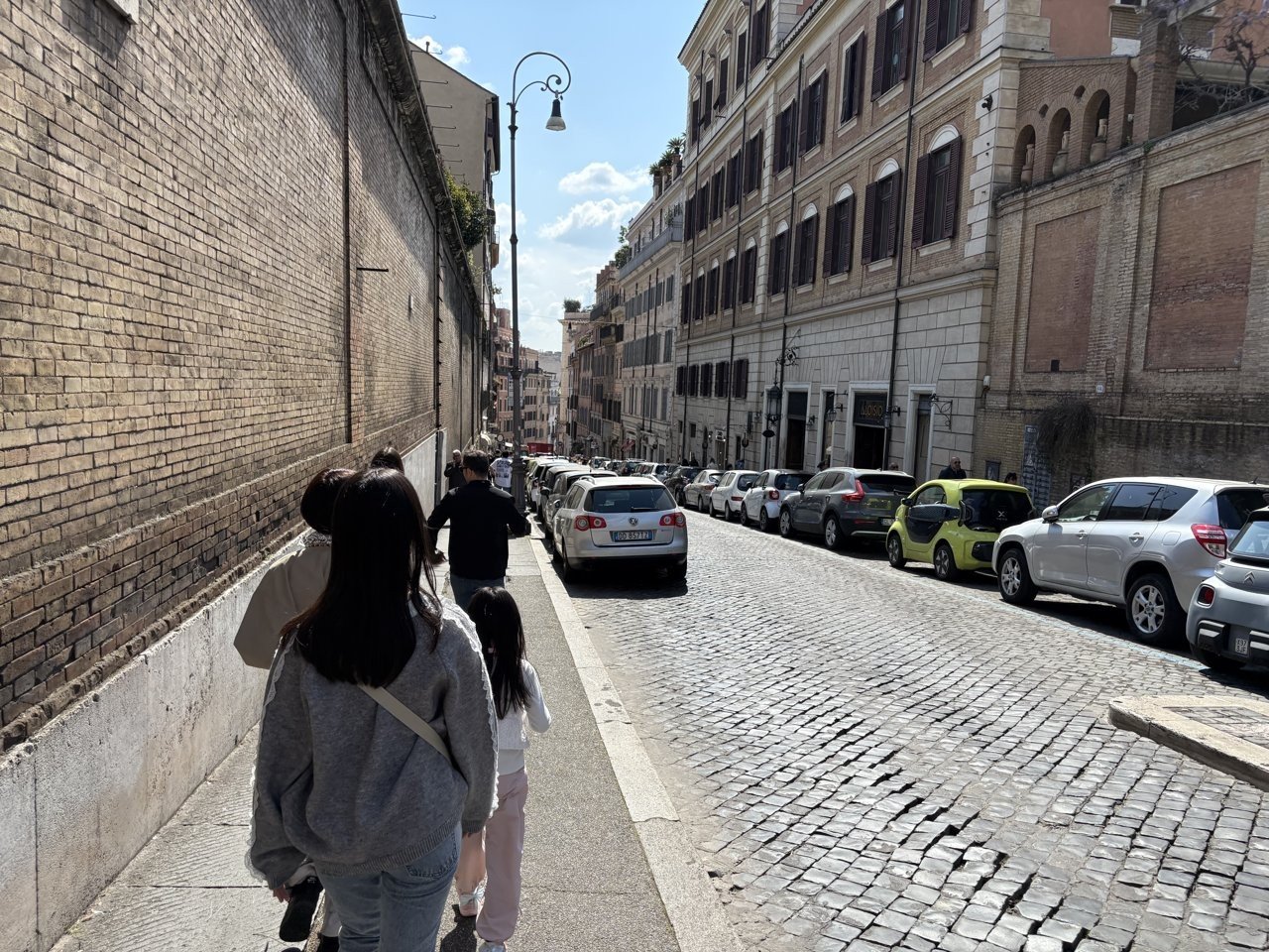 A street in Rome: a narrow pavement and a road of solid cobbles - the kind of surface that wears down suitcases and strollers