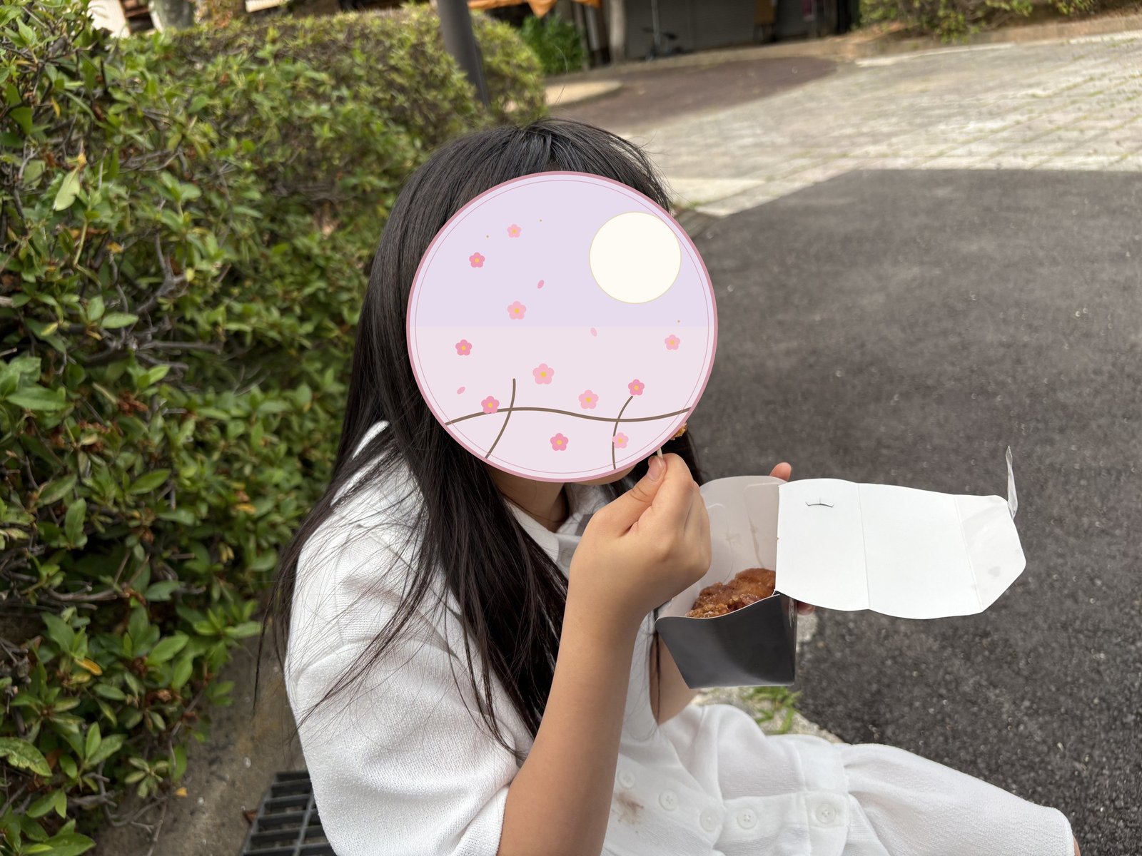 唐戸市場で買ったからあげ串を頬張る娘